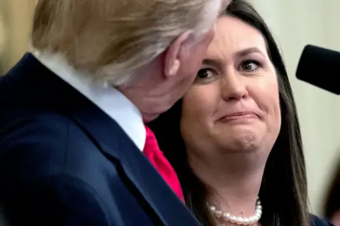Saul Loeb / Getty Images White House Press Secretary Sarah Huckabee Sanders looks at President Trump