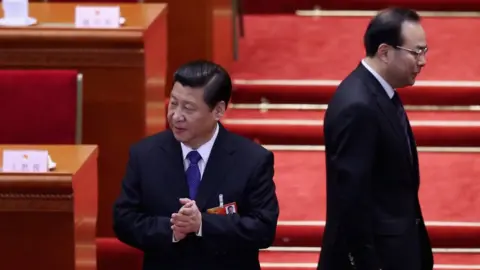 Getty Images Communist Party Secretary of Chongqing Sun Zhengcai (R) walks behind Chinese President Xi Jinping (L) as they attending the fifth plenary meeting of the National People's Congress at the Great Hall of the People on 15 March 2013 in Beijing, Chin