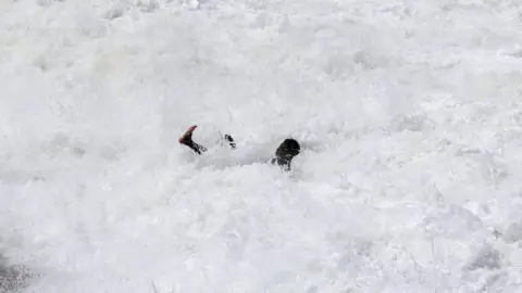 Feisal Omar/ Reuters A man plays in water on 21 July 2023.