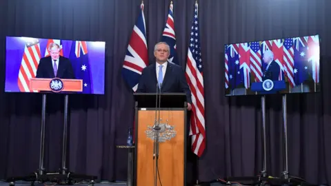 EPA Scott Morrison (centre) speaks in a joint virtual press conference with his US and UK counterparts in announcing the Aukus security pact.