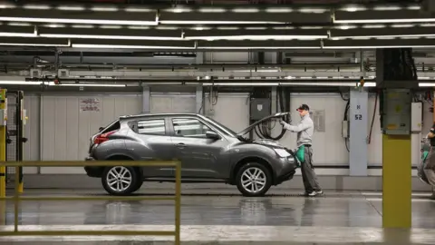 Getty Images A worker with a Nissan Juke at the factory in Sunderland