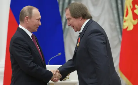 Getty Images Vladimir Putin (L) shakes hands with Russian cellist Sergei Roldugin during an awarding ceremony at the Kremlin in Moscow on September 22, 2016