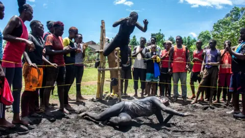 ISAAC KASAMANI/EPA Members of Uganda's Soft Ground Wrestling compete in a makeshift wrestling ring at their camp in the village of Kilangila, Mukono District, Uganda, 06 March 2024.