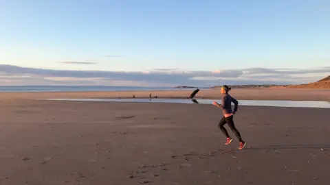 Ellie Lacey running on the beach