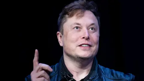 Getty Images Elon Musk raises a finger while speaking in this file photo from March 2020