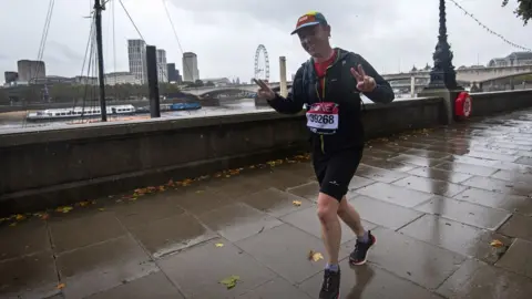 Press Association A runner wearing a London Marathon running number on the Embankment in central London