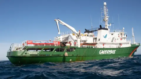 Suzanne Plunkett / Greenpeace Greenpeace ship dropping a boulder into the sea