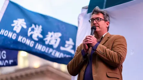 Getty Images Benedict Rogers speaking at a rally in London in 2021