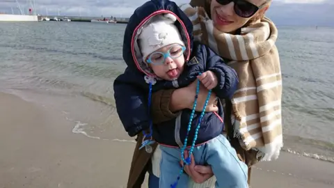 Mateusz Maranowski Mother with baby praying on a beach in Gdynia