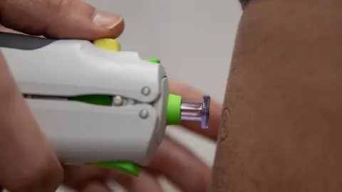 Cambridge University Hospitals Trust Person having a needle-free vaccination