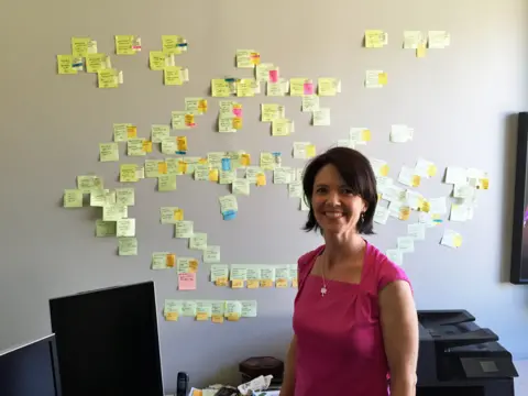 Alex Tresniowksi Genealogist Michelle Trostler in front of the 'wall of stickies' she assembled for the case