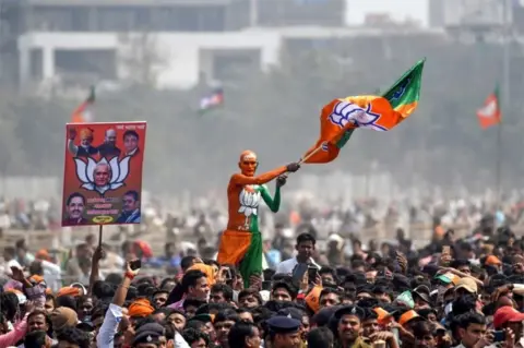 AFP An Indian Bharatiya Janata Party (BJP) supporter waves a flag among the crowd of other supporters listening to Prime Minister Narendra Modi during the National Democratic Alliance (NDA) "Sankalp" rally in Patna in the Indian eastern state of Bihar on March 3, 2019