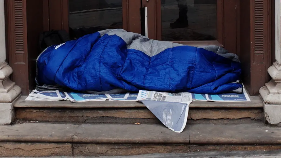 Getty Images person sleeping at a door entrance