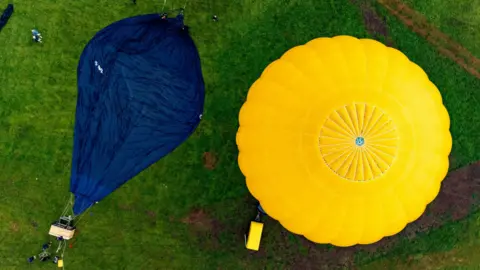 PA MediaBen Birchall/PA Wire Two hot air balloon canopies on the grass