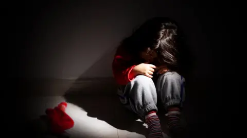 Getty Images A little girl in a shadowy room