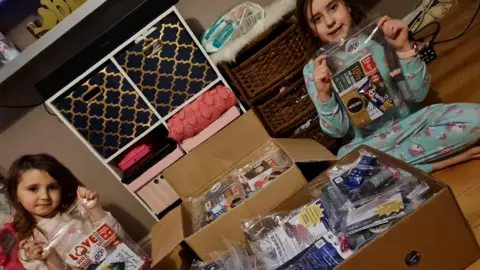 Bobbi Cockroft Two children helping to prepare the Hugs for Heroes goody bags