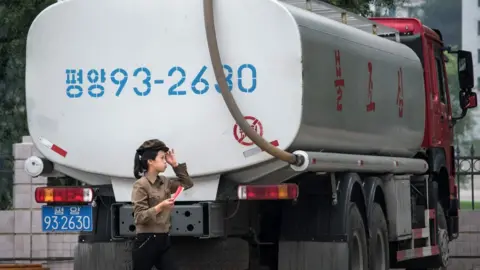 AFP A petrol station worker walks past a fuel truck in Pyongyang