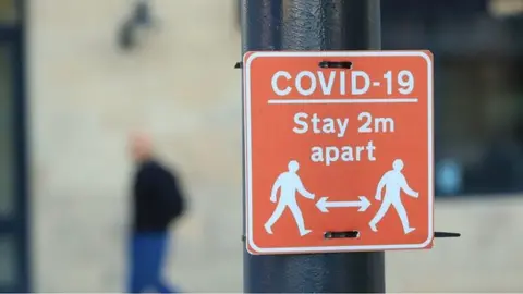 PA Media A "stay 2m apart" sign