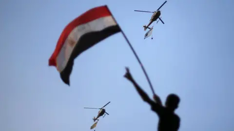 Reuters Egyptian military helicopters fly above Cairo's Tahrir Square during a protest against then-President Mohammed Morsi (1 July 2013)