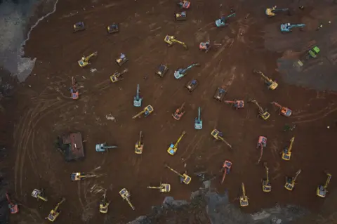Getty Images An aerial view of cranes and diggers building Huoshenshan Hospital