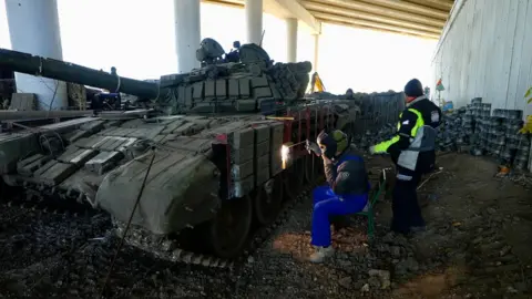 People work on a tank