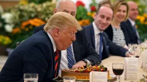 EPA US President Donald Trump blowing out the candle of a birthday cake during lunch with Singapore's Prime Minister Lee Hsien Loong (not seen) in Singapore on 11 June 2018