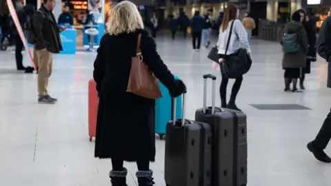 Getty Images Woman at station with bags