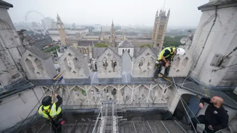 PA Media Abseilers work on top of the West Towers