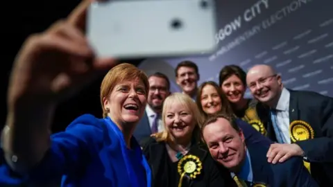 Getty Images First Minister Nicola Sturgeon takes a selfie with some of her newly elected MPs at the Glasgow count