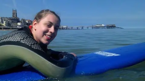 Abrahart family Natasha Abrahart on a paddleboard in the sea, smiling