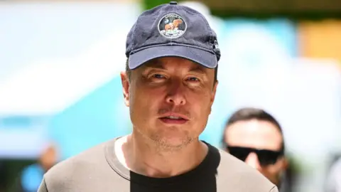 Getty Images Elon Musk walks in the Paddock prior to final practice ahead of the F1 Grand Prix of Miami.