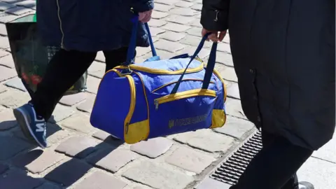 Reuters Refugees carrying a bag