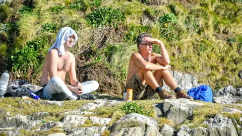 PA Two men with their shirts off on a sunny day