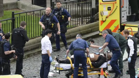 PA Emergency services at the scene while two knives lay on the floor outside the Palace of Westminster