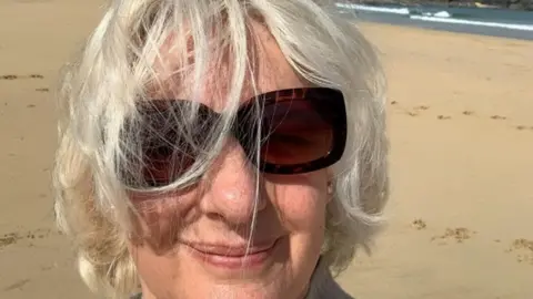 University of Bristol/PA Wire A woman wearing sunglasses, smiling on the beach