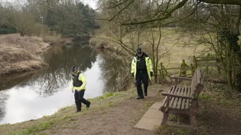 PA Media Police activity near the bench by the River Wyre in St Michael's on Wyre, Lancashire, where the mobile phone was found