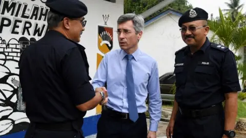 AFP France's ambassador to Malaysia Frederic Laplanche with police officers