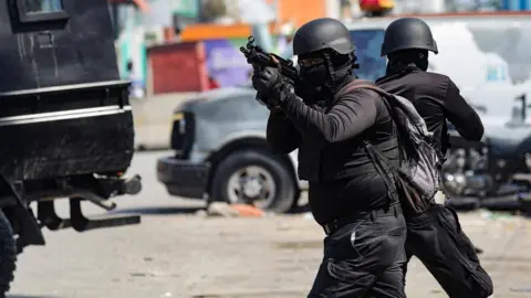 Reuters Police officers in military gear hold guns on the streets of Port-au-Prince