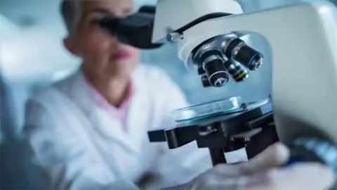 Getty Images Researcher with microscope