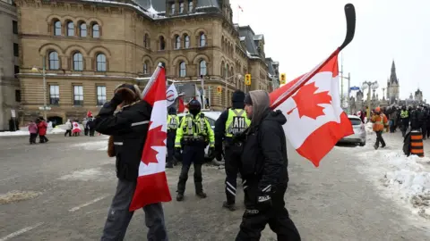 Reuters Police officers keep a watchful eye on protesters in Ottawa, 6 February