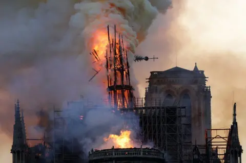 AFP The steeple collapses as smoke and flames engulf the Notre-Dame Cathedral in Paris