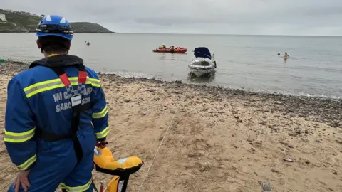 Mumbles Coastguard rescuers pulling boat ashore