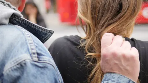 Salvation Army Male gripping girl by hair