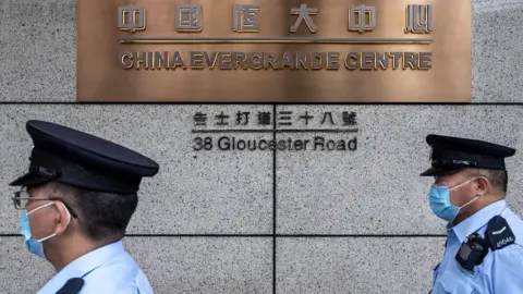 Getty Images Police officers walk past the China Evergrande Centre in Hong Kong.