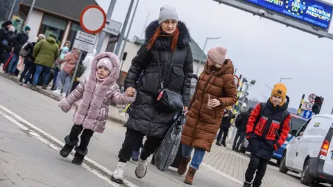 Getty Images A family crossing the border into Poland from Ukraine