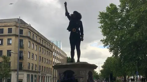 Jen Reid standing on plinth