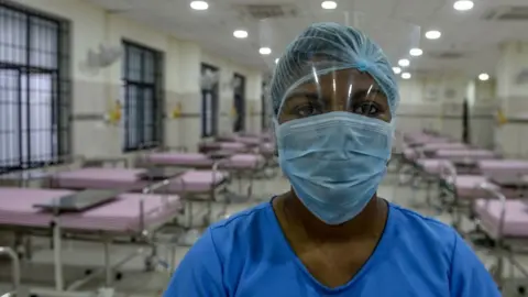 Getty Images A medical staff wearing a facemask poses in an isolation ward at a newly inaugurated hospital by the Tamil Nadu state during a government-imposed nationwide lockdown as a preventive measure against the COVID-19 coronavirus, in Chennai on March 27, 2020.