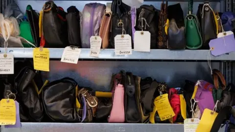 TfL Image of shelves containing rows of handbags, with numbered tags hanging from them