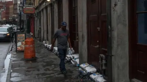 AFP A man walks past sand bags in New Orleans