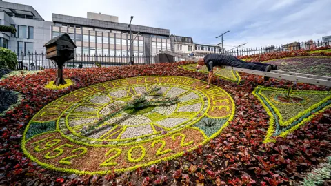 PA Media Head gardener David Dorward next to this year's design on the world's oldest Floral Clock in West Princes Street Gardens in Edinburgh, on day one of the Platinum Jubilee celebrations.